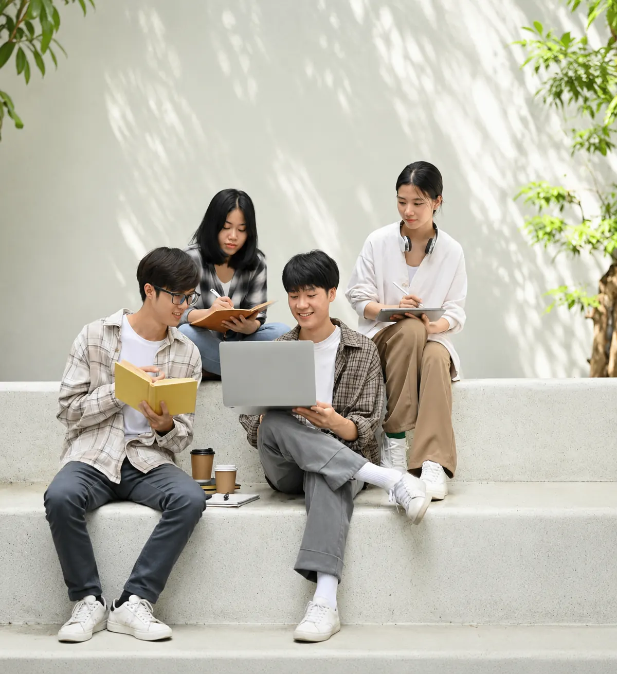 Four students studying together on outdoor steps