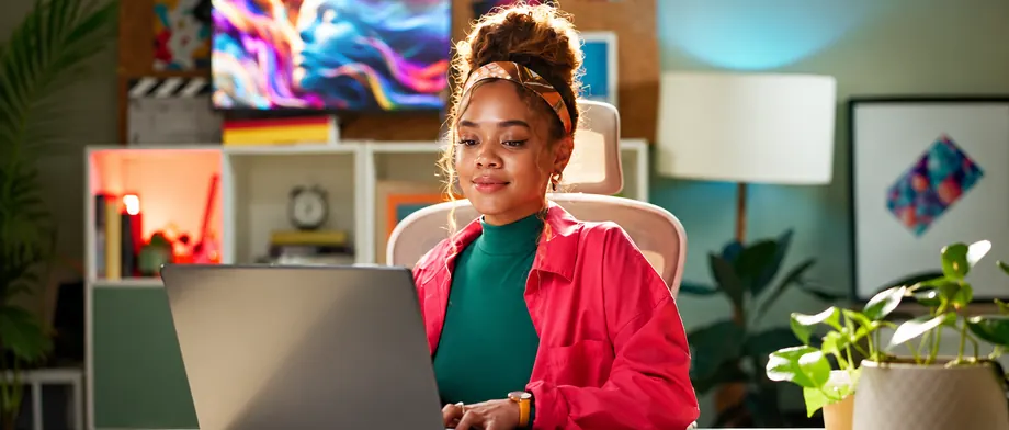 A professional working at a laptop in a bright home office