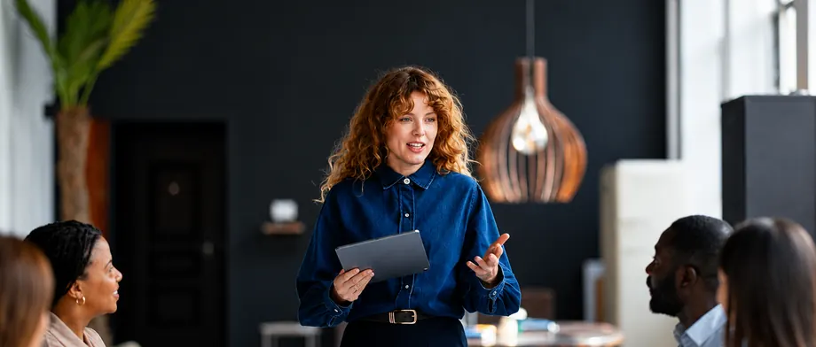 A leader presenting to colleagues around a meeting table