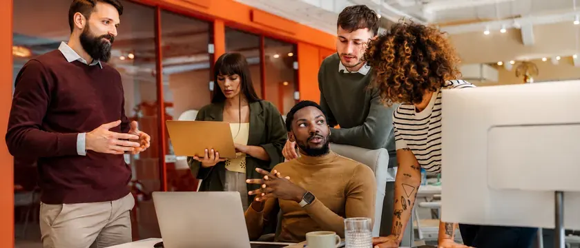 A team talking around a desk in an open office