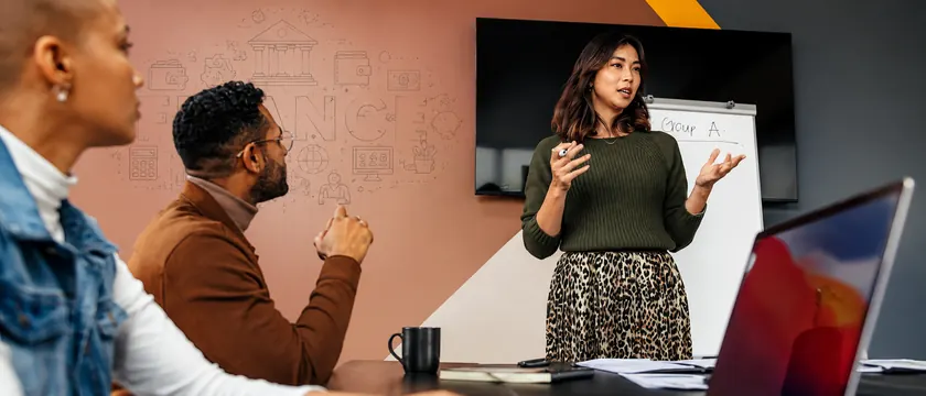 A colleague presenting to a small team in a meeting room