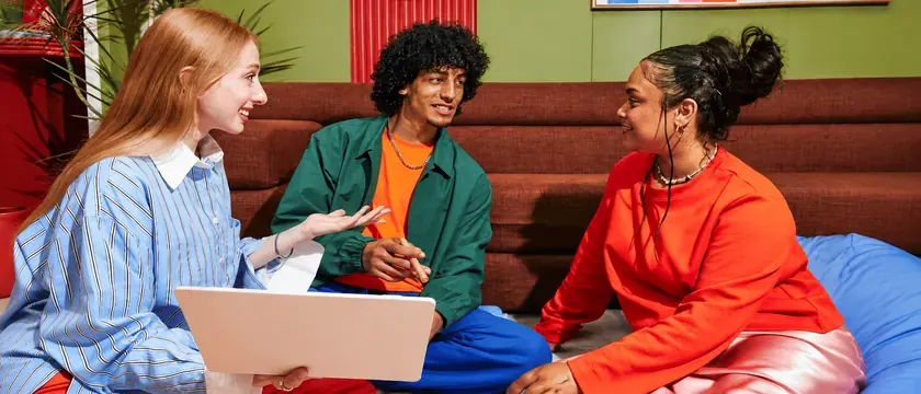 Three colleagues talking together on a sofa